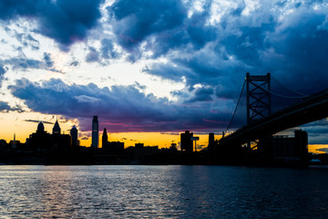 Obraz premium zachód słońca panoramę filadelfii w Pensylwanii z camden new jersey z mostem benjamina franklina