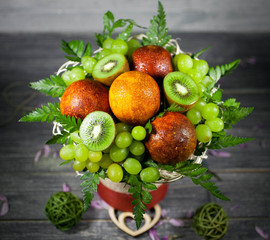 Bouquet from fruit and berries. composition on a wooden background