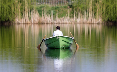 Silent couple in a rowboat. Melancholy and peaceful atmosphere