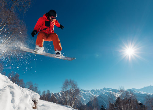 snowboarder is jumping with snowboard from snowhill