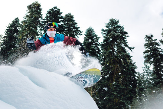 snowboarder is jumping, riding and freeriding the mountain forest