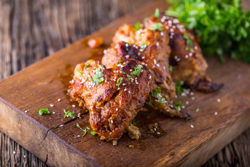 Chicken wings grilled BBQ  parsley herb and sesame on wooden board.