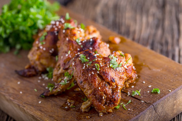 Chicken wings grilled BBQ  parsley herb and sesame on wooden board.