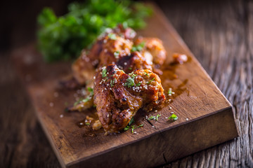 Chicken wings grilled BBQ  parsley herb and sesame on wooden board.