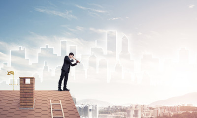 Engineer man standing on roof and looking in spyglass. Mixed med