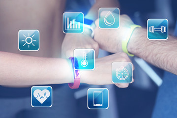 Hands of young people with fitness trackers in gym, closeup