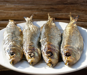 Geräucherter Fisch / Bücklinge auf Teller mit Holz / Treibholz Hintergrund, Textfreiraum