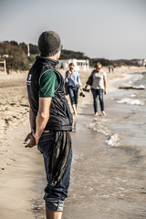 Mann mit Mütze und Weste am Strand in der Region Lecce in Italien