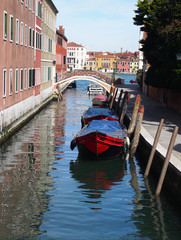 Fototapeta na wymiar venice canal with red boat and bridge