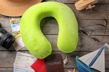 Travel pillow and things for traveling on wooden background