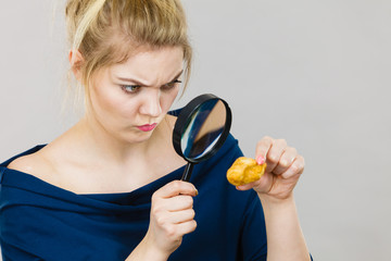 Woman holding magnifying glass investigating bread
