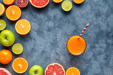 Juice or smoothie with citrus fruit, apple, grapefruit on blue background. Top view, selective focus. Detox, dieting, clean eating, vegetarian, vegan, fitnes healthy concept