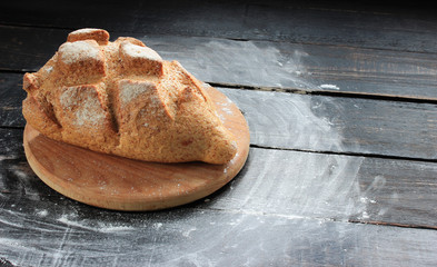 Homemade bread on a cutting board with flour