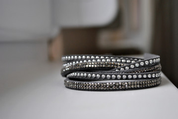 Close up of grey leather bracelet with studs - fachion and object concept.