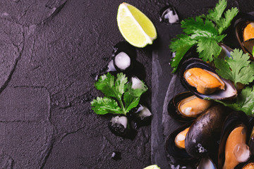 Obraz na płótnie Canvas Uncooked mussels on ice with cilantro and coriander