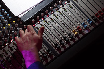Sound mixer. Professional audio mixing console with lights, buttons, faders and sliders. With hand