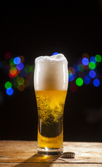 Glass of beer on bar lights background