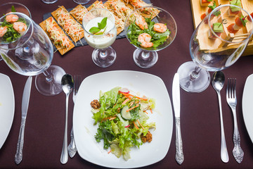 A first person view, a man is dining in the restaurant, a salad and orders are on the table
