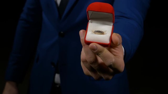 Business man proposing and showing engagement ring box