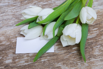 white tulips bouquet and blank greeting card