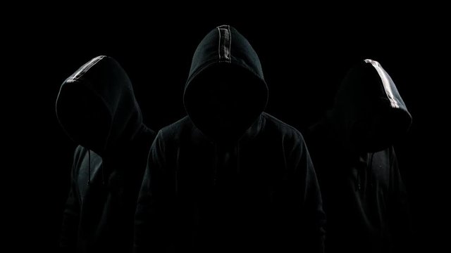 Mysterious hooded man standing in the dark