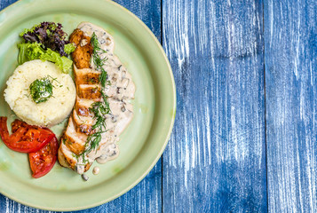 Meat sliced with sauce, tomatoes, herbs and potatoes