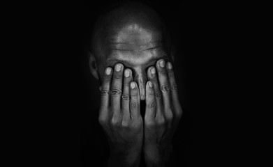 Sad man covered his face with his hands