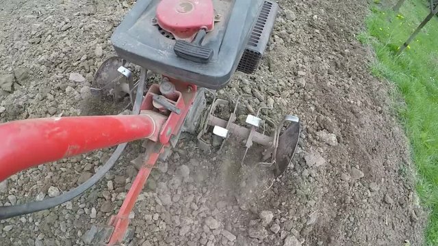 Closeup of hand motor plow blade throwing clay.
Focus on the preparation of agricultural land.
Slowmotion.