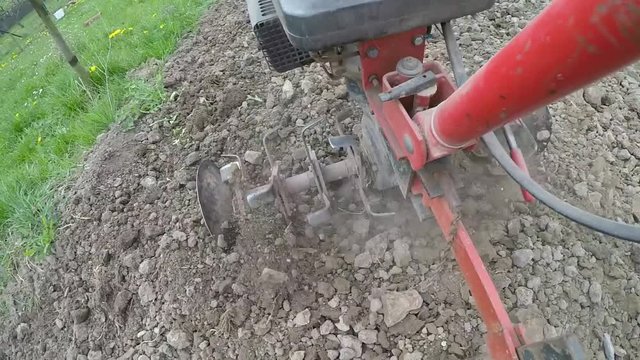 Closeup of hand motor plow blade throwing clay.
Focus on the preparation of agricultural land. Slowmotion.
