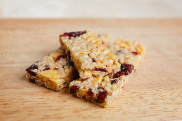 Muesli bar close up, three bars one partially covered with dry fruits and one bit