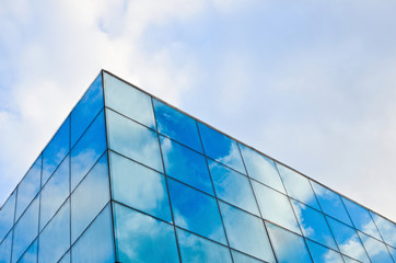 Fototapeta na wymiar Blue sky with white clouds reflected in the windows. Abstract background for business purposes.