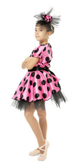 Young girl in pink polka dot dress with black tulle and ballet slippers, isolated on white background, she wears a matching black and pink hair accessory © Africa Studio