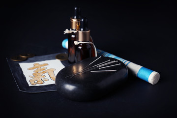 Acupuncture supplies on black background