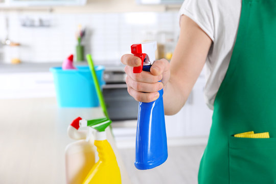 Cleaning service worker holding bottle with cleanser, closeup