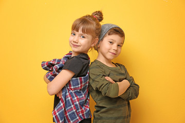 Cute stylish children on color background