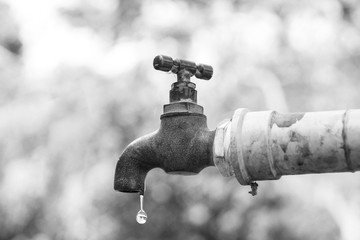 A faucet with a water drop / Water consumption and shortage concept