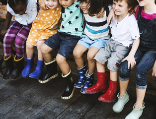 Group of kindergarten kids friends arm around sitting and smiling fun