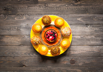 Delicious homemade muffins with yogurt, on a wooden background with space for text.