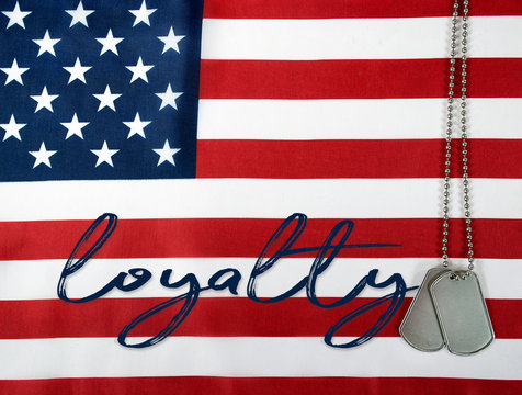 word loyalty and military dog tags on American flag