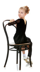 Slender little dancer posing near the old Vienna chair.