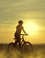 Girl on a bicycle in the sunset.