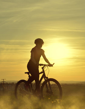 Girl on a bicycle in the sunset.