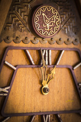Old wooden wall clock with a cuckoo close up.