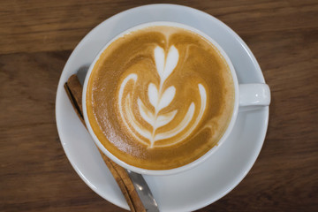 Coffee With Latte Art On Wooden Table