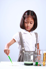 Little girl holding a test tube with liquid Scientist chemistry and science education concept