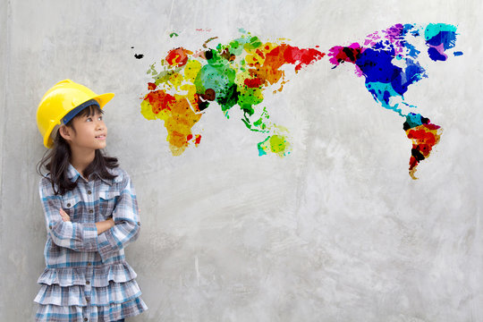 Little girl engineering with watercolor world map on wall