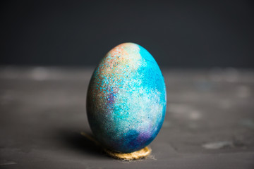 Colored easter egg on the dark background. Shallow depth of field.