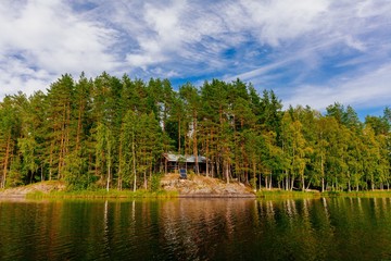 Wooden log cabin at the lake in summer in Finland