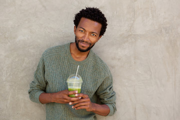 handsome african american man holding fruit juice drink