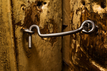 Old closed metal hook on a wooden door